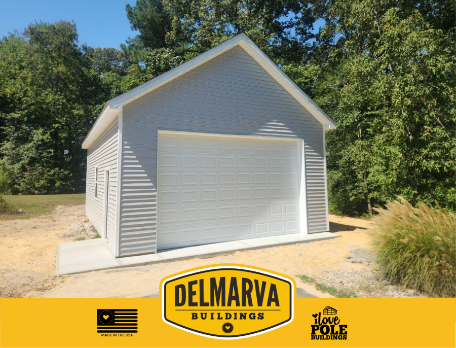Light gray pole barn garage with white trim and overhead door by Delmarva Buildings.