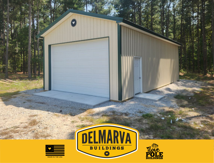 Beige pole barn garage with green trim and white doors by Delmarva Buildings.