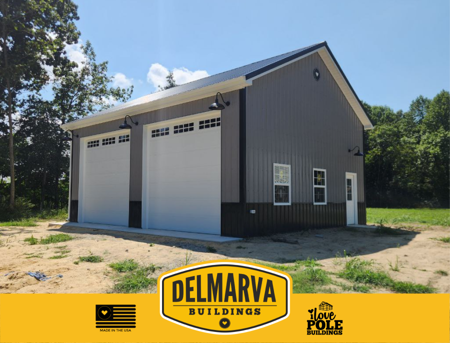 Grey and black pole barn two-bay garage with white doors by Delmarva Buildings.