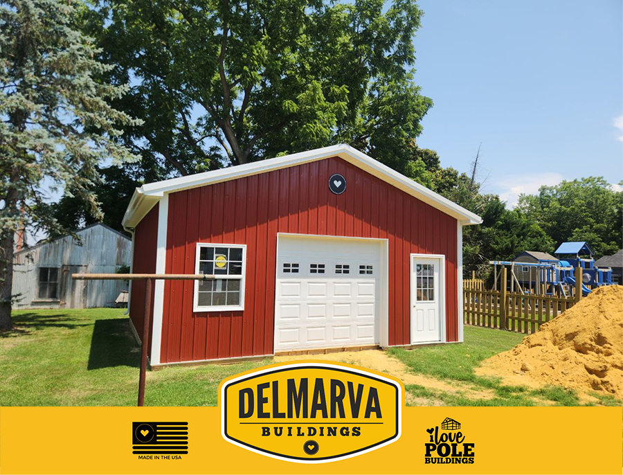 Red pole barn with white trim, white garage door, and side window.