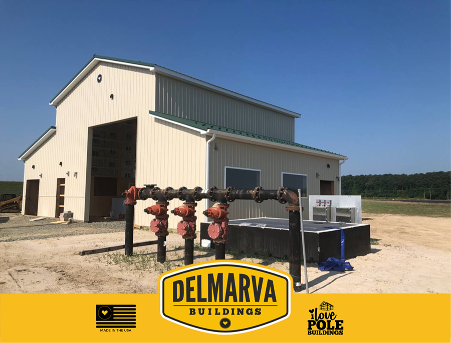 Cream and green pole barn with large open bays and metal roof by Delmarva Buildings.