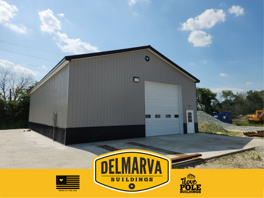 Modern gray and black pole barn with a white door by Delmarva Buildings.