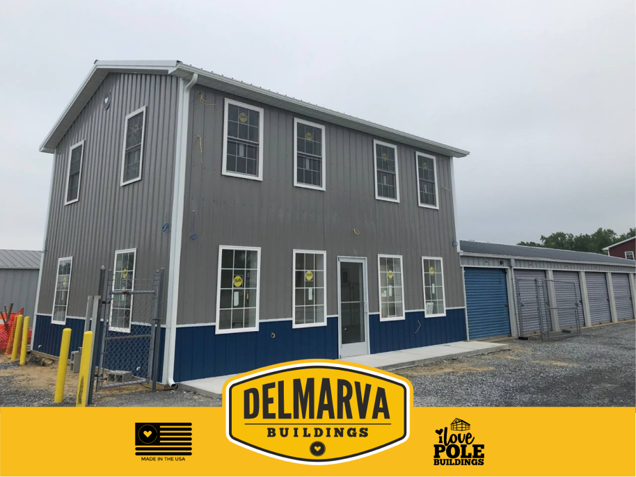 Gray and blue pole barn building with multiple windows and white trim.