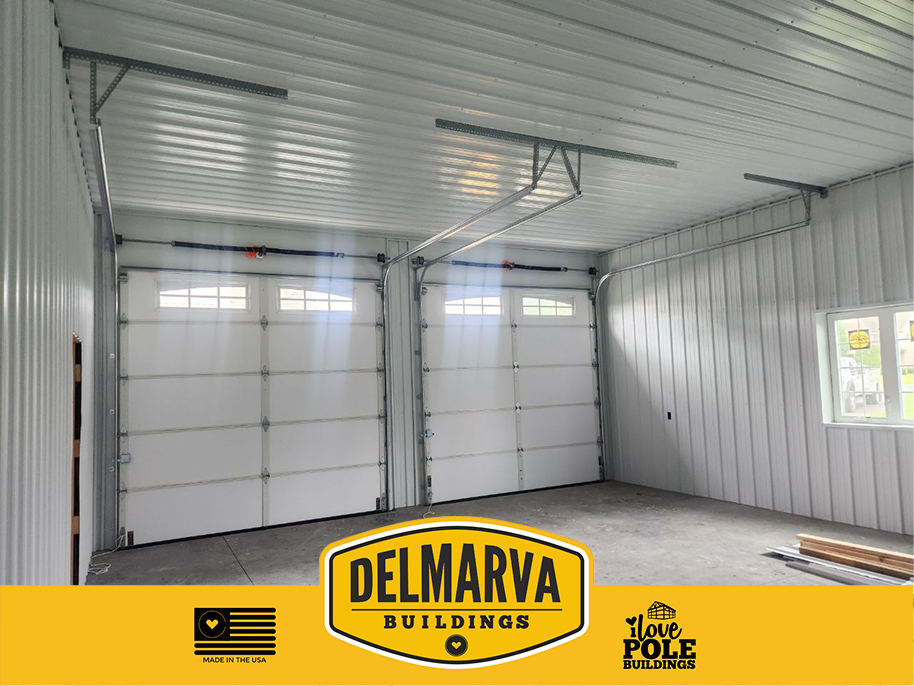 Interior of two-bay garage with white doors and metal frame by Delmarva Buildings.