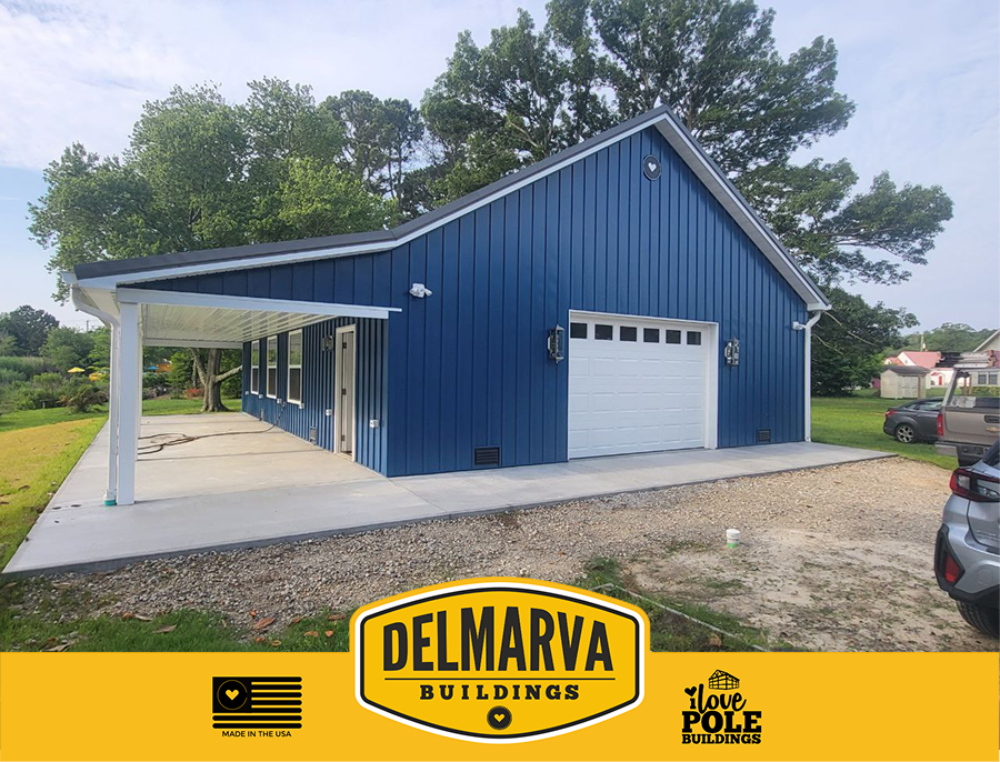 Blue pole barn with white garage door, sheltered porch, and white trim by Delmarva Buildings.