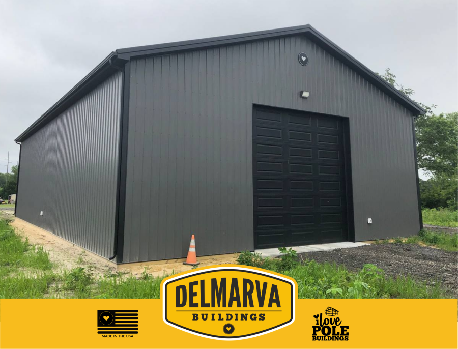 Dark gray pole barn with a black door by Delmarva Buildings.