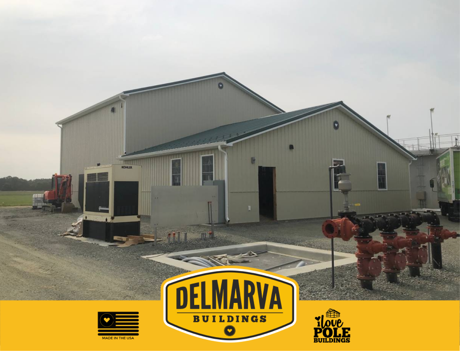 Tan and black pole barn with metal roof, entry door and multiple windows by Delmarva Buildings.