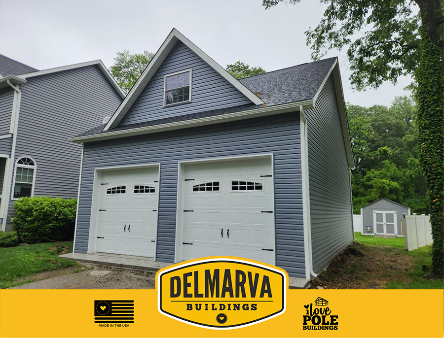 Gray two-bay garage with white doors and gable roof by Delmarva Buildings.