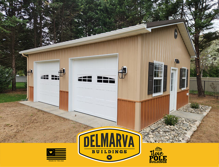 Tan and rust pole barn with two white garage doors and side entry by Delmarva Buildings.