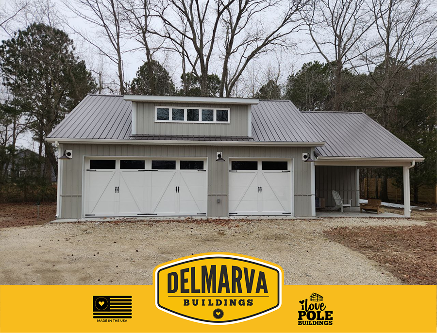 Cream pole barn with three white garage doors, metal roof, and a side porch area by Delmarva Buildings.