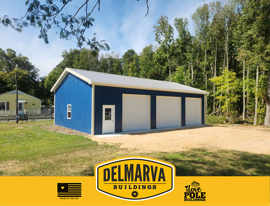 Blue and white three-bay garage with white doors and entry door by Delmarva Buildings.