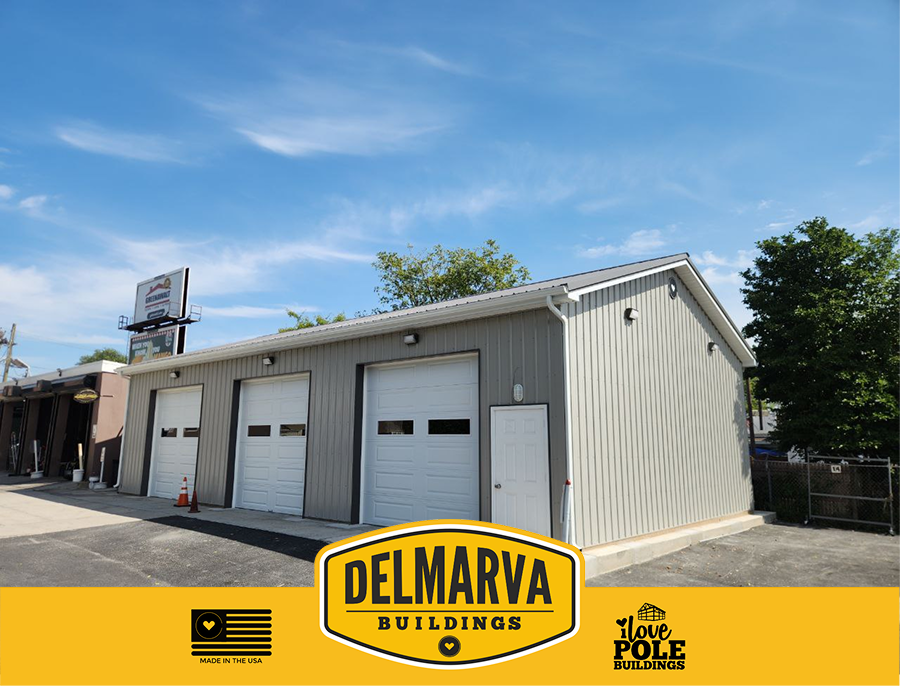 Tan pole barn with three white garage doors and side entry door by Delmarva Buildings.